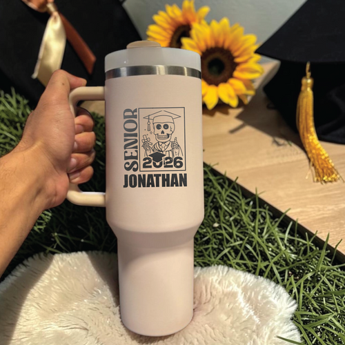 White mug with 'Senior 2026 Jonathan' design held by a hand, with sunflowers and a graduation cap in the background.